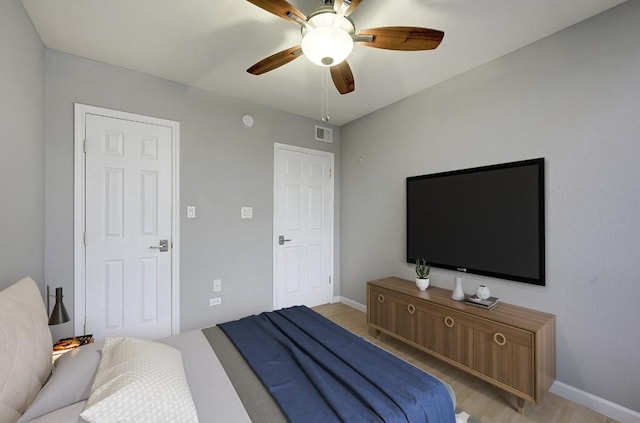 bedroom with light hardwood / wood-style floors and ceiling fan