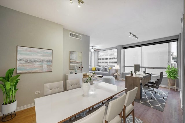 dining space featuring hardwood / wood-style floors, expansive windows, and ceiling fan