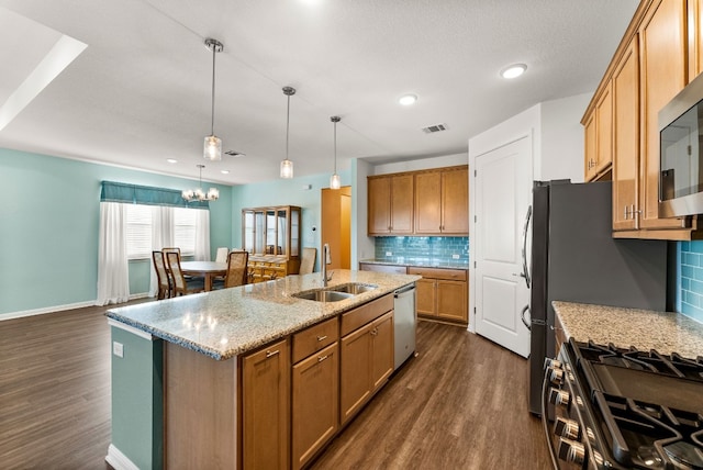 kitchen with a kitchen island with sink, sink, decorative backsplash, dark hardwood / wood-style floors, and stainless steel appliances