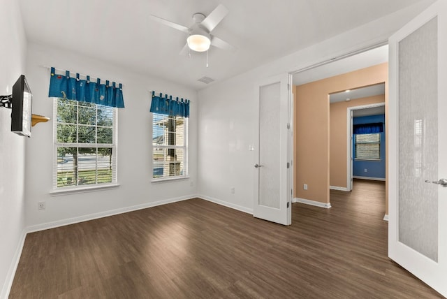 unfurnished room with ceiling fan, dark hardwood / wood-style flooring, and a healthy amount of sunlight