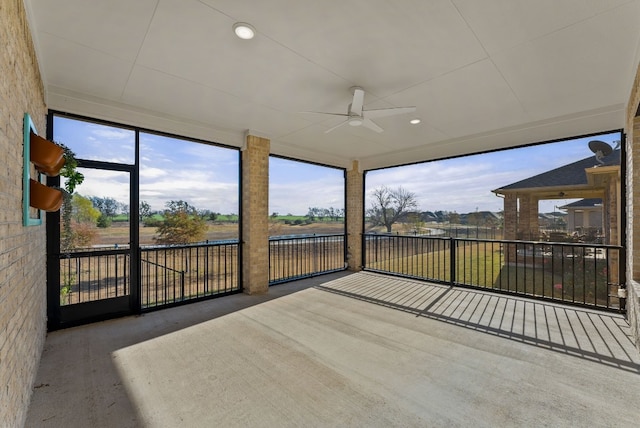 unfurnished sunroom featuring ceiling fan