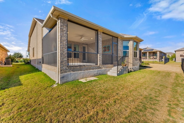 rear view of house featuring a lawn, ceiling fan, and central AC unit