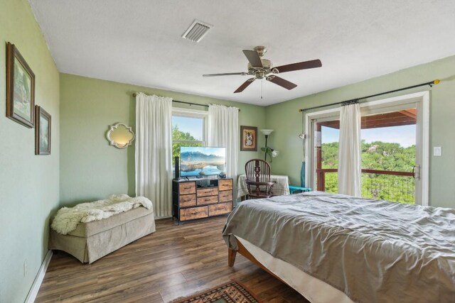 bedroom with ceiling fan, visible vents, baseboards, and dark wood-style floors