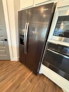 kitchen featuring white cabinets, appliances with stainless steel finishes, and wood-type flooring