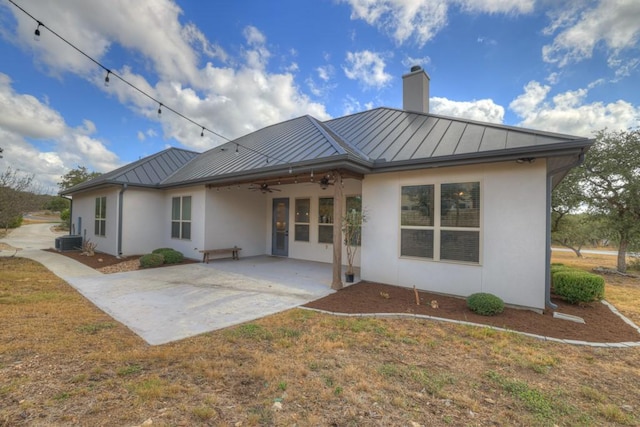 rear view of house featuring a lawn, ceiling fan, cooling unit, and a patio