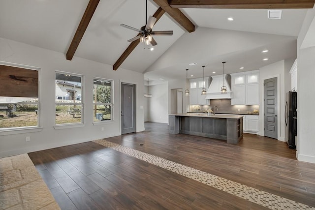 kitchen featuring custom exhaust hood, a spacious island, decorative light fixtures, white cabinets, and stainless steel refrigerator