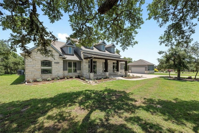 view of front of property featuring a porch, a garage, a front yard, and cooling unit