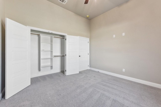 unfurnished bedroom with light carpet, a closet, and ceiling fan