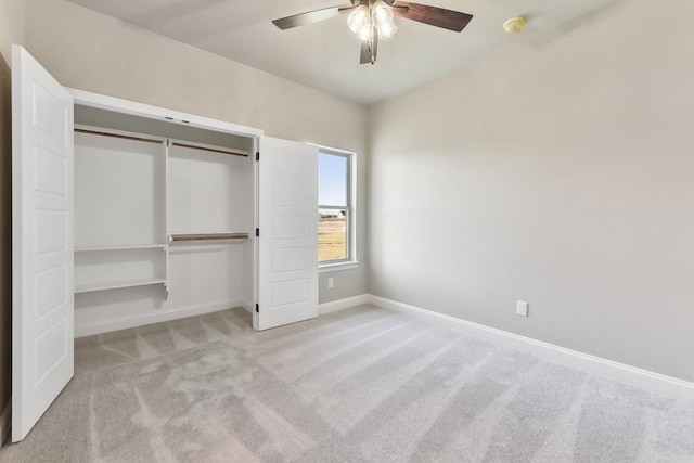 unfurnished bedroom featuring light carpet, a closet, and ceiling fan