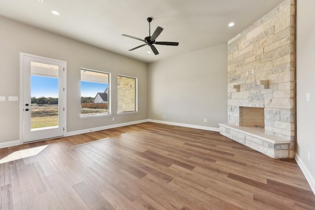 unfurnished living room with a fireplace, light wood-type flooring, and ceiling fan