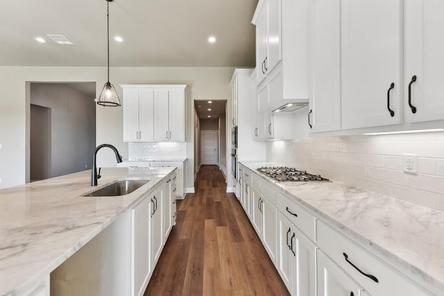 kitchen with white cabinetry, sink, decorative light fixtures, and stainless steel gas stovetop