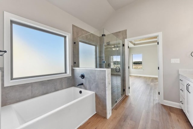 bathroom featuring hardwood / wood-style floors, vanity, shower with separate bathtub, and vaulted ceiling