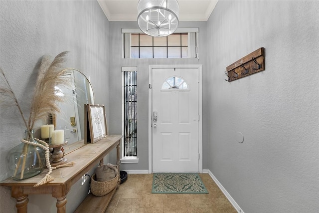 entryway with ornamental molding and a notable chandelier