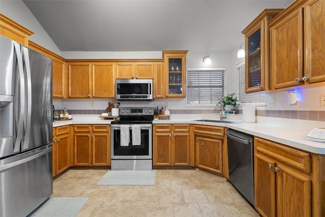 kitchen featuring tasteful backsplash, sink, stainless steel appliances, and vaulted ceiling