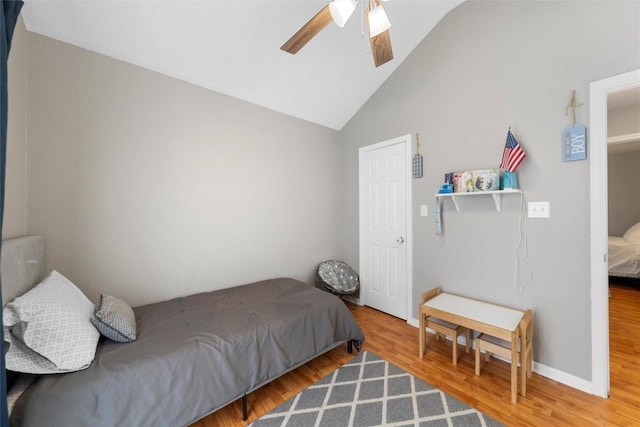 bedroom with hardwood / wood-style floors, ceiling fan, and vaulted ceiling