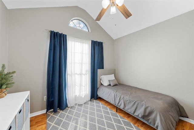 bedroom with ceiling fan, light hardwood / wood-style flooring, and vaulted ceiling