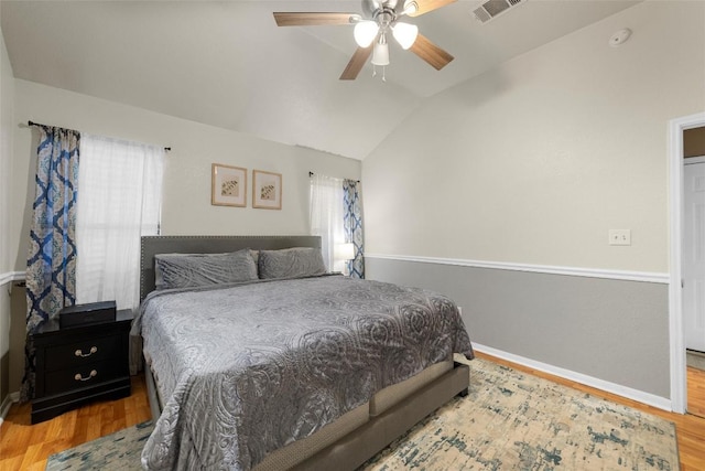 bedroom with ceiling fan, light hardwood / wood-style floors, and lofted ceiling