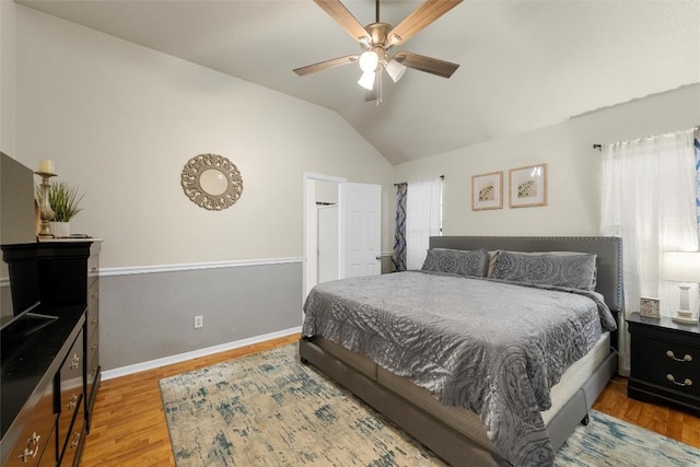 bedroom featuring wood-type flooring, vaulted ceiling, and ceiling fan