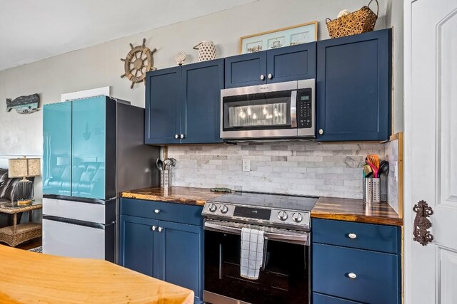 kitchen with butcher block countertops, blue cabinetry, and appliances with stainless steel finishes