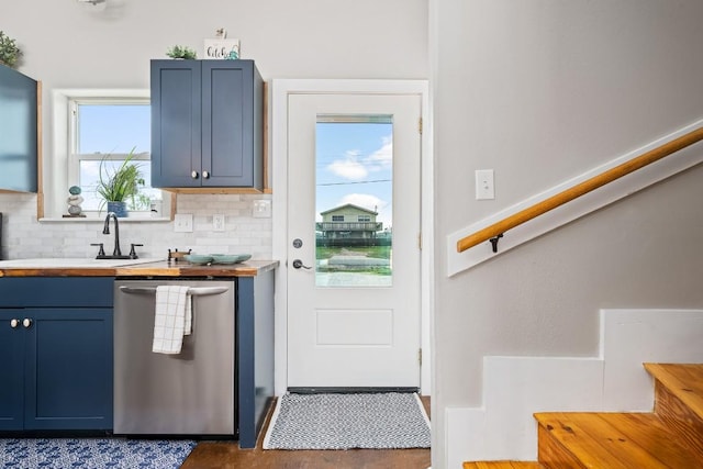 kitchen with decorative backsplash, sink, stainless steel dishwasher, and blue cabinets