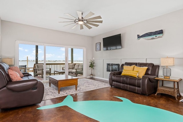 living room with ceiling fan and a water view