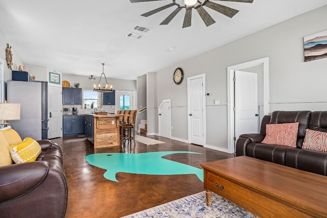 living room with ceiling fan with notable chandelier