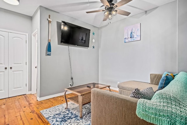 living area featuring hardwood / wood-style floors and ceiling fan