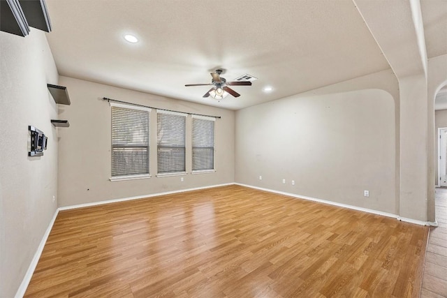 empty room with ceiling fan and light hardwood / wood-style floors