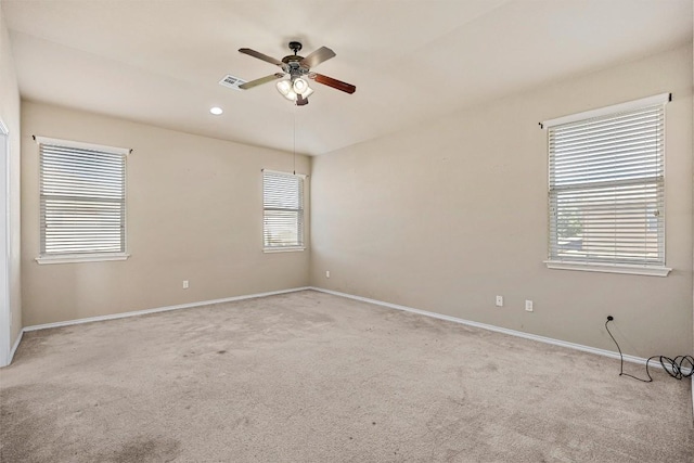 empty room with light carpet, ceiling fan, and a healthy amount of sunlight