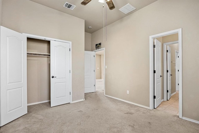 unfurnished bedroom featuring ceiling fan, light carpet, and a closet