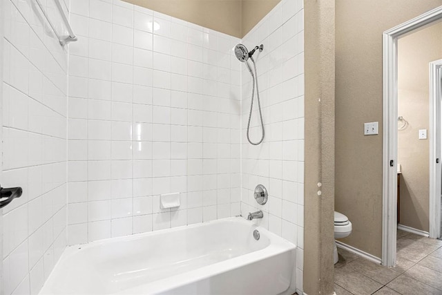 bathroom featuring tile patterned floors, tiled shower / bath combo, and toilet