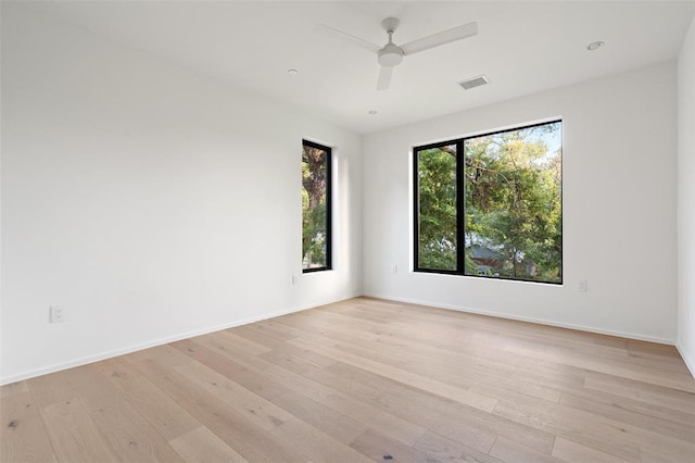 empty room with ceiling fan and light hardwood / wood-style flooring