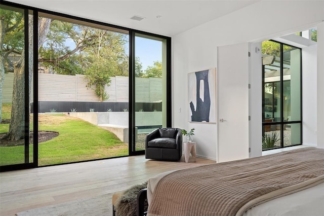 bedroom featuring hardwood / wood-style floors and expansive windows