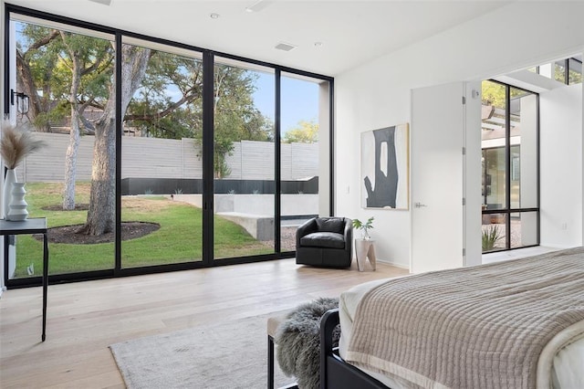 bedroom with light hardwood / wood-style flooring and expansive windows