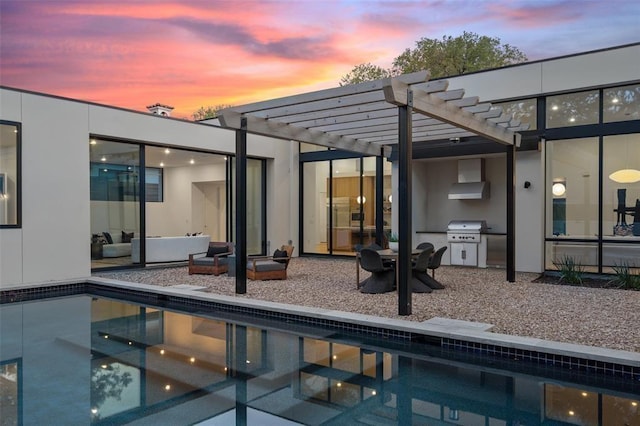 back house at dusk with an outdoor hangout area, a patio area, a pergola, and exterior kitchen