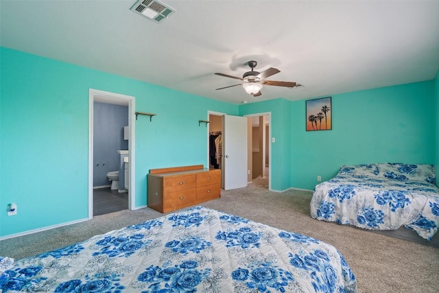 bedroom featuring carpet flooring, ensuite bath, ceiling fan, and a spacious closet