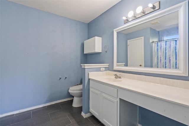 bathroom with curtained shower, vanity, and toilet