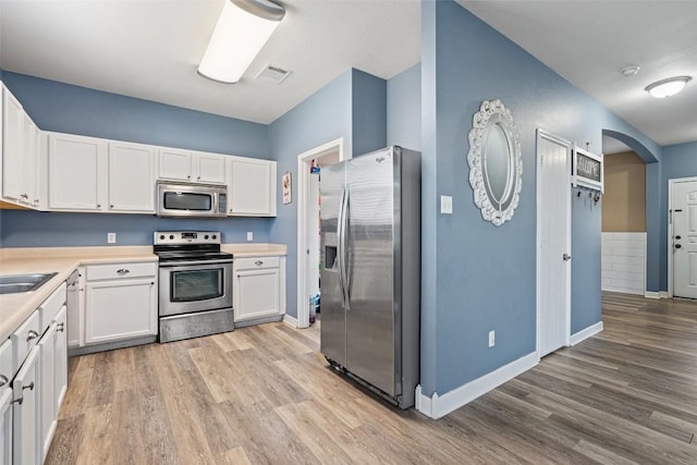 kitchen featuring white cabinetry, appliances with stainless steel finishes, and light hardwood / wood-style flooring