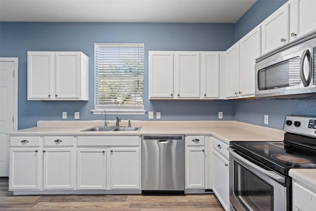 kitchen featuring white cabinets, light wood-type flooring, sink, and appliances with stainless steel finishes