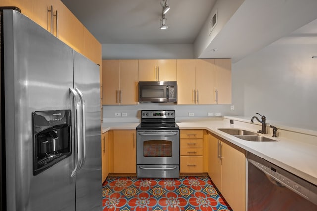 kitchen featuring light brown cabinetry, sink, dark tile patterned floors, and stainless steel appliances