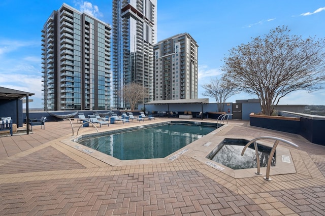 view of pool with a patio and a hot tub