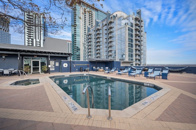 view of pool featuring a community hot tub and a patio area