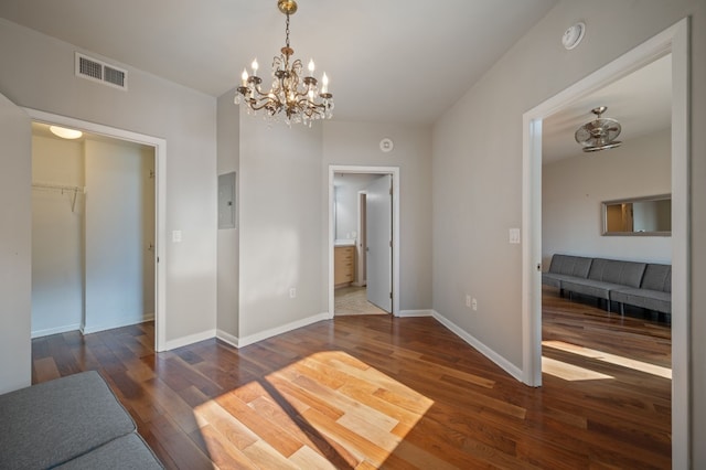 interior space with dark wood-type flooring, electric panel, and an inviting chandelier