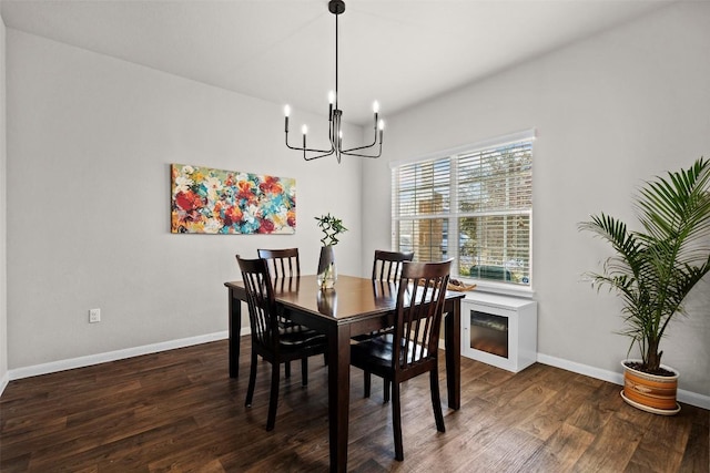 dining area with a chandelier, wood finished floors, and baseboards