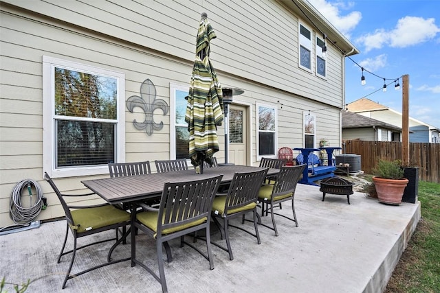 view of patio with an outdoor fire pit, fence, and outdoor dining space
