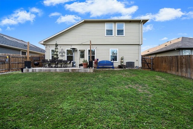 rear view of property featuring a patio, cooling unit, and a lawn