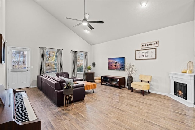 living room with light hardwood / wood-style flooring, plenty of natural light, high vaulted ceiling, and ceiling fan