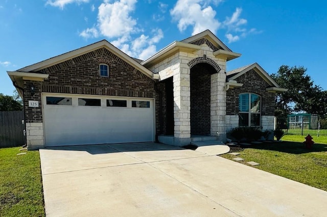 125 Millsaps Ct, Bastrop, TX 78602 - french country home featuring driveway, an attached garage, and brick siding