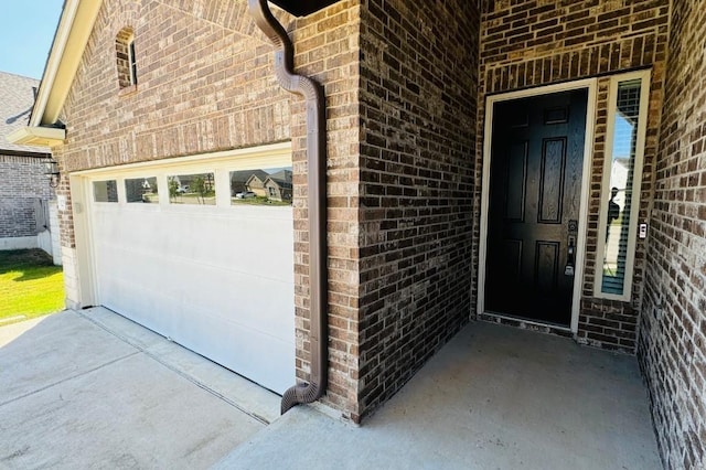 125 Millsaps Ct, Bastrop, TX 78602 - doorway to property featuring brick siding, concrete driveway, and an attached garage