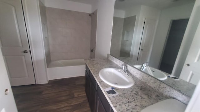 bathroom featuring vanity, wood-type flooring, and tiled shower / bath combo